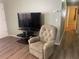 Living room with hardwood floors, a recliner, and a large TV at 1601 Berwick Ct # B, Palm Harbor, FL 34684