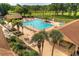 Aerial view of refreshing community pool with lounge chairs and lush landscaping at 1601 Berwick Ct # B, Palm Harbor, FL 34684