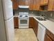 Well-maintained kitchen with wood cabinets and white appliances at 1601 Berwick Ct # B, Palm Harbor, FL 34684