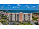 Aerial view of a waterfront condo building with parking and lush landscaping at 19029 Us Highway 19 N # 9-706, Clearwater, FL 33764