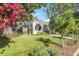 White stucco home with lush landscaping, palm trees, and a vibrant bougainvillea at 3015 W San Nicholas St, Tampa, FL 33629