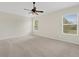 Main bedroom with ceiling fan, neutral carpeting, and two windows at 30619 White Bird Ave, Wesley Chapel, FL 33543