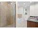 Bright bathroom with a glass shower enclosure, soaking tub, double vanity, and natural light from a window at 450 Knights Run Ave # 407, Tampa, FL 33602