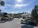 Outdoor patio with picnic tables, umbrellas, string lights, lush greenery and city skyline in background at 450 Knights Run Ave # 407, Tampa, FL 33602
