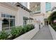 Beautiful building exterior with a paved walkway, lush green shrubs, and architectural details at 450 Knights Run Ave # 407, Tampa, FL 33602