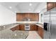 Modern kitchen with granite countertops, stainless steel appliances, and wood cabinetry at 450 Knights Run Ave # 407, Tampa, FL 33602