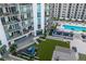 An aerial view of a community area showcasing a pool, lush lawn, lounge seating, and manicured landscaping at 450 Knights Run Ave # 407, Tampa, FL 33602