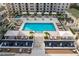 An aerial view of the pool and courtyard area featuring lounge chairs, umbrellas, lush landscaping, and inviting spaces at 450 Knights Run Ave # 407, Tampa, FL 33602