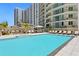 Resort-style pool deck surrounded by high-rise condos, lounge chairs, and manicured landscaping, providing a relaxing oasis at 450 Knights Run Ave # 407, Tampa, FL 33602