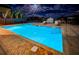 Night view of a resort-style pool with surrounding lounge chairs at 455 Pinellas Bayway S # 2A, Tierra Verde, FL 33715