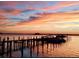 Stunning sunset over the water, a long dock, and calm water at 632 Edgewater Dr # 532, Dunedin, FL 34698