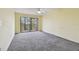Bedroom with gray carpet, ceiling fan, and sliding glass doors at 8198 Terrace Garden N Dr # 403, St Petersburg, FL 33709