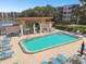 Community pool with patio, lounge chairs, and BBQ area at 8198 Terrace Garden N Dr # 403, St Petersburg, FL 33709