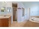 Bathroom with a shower, garden tub, and double vanity with wood cabinets at 11004 Carnes St, Weeki Wachee, FL 34613