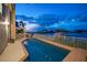 Inviting heated pool with waterfront views at dusk at 18 Winston Dr, Belleair, FL 33756