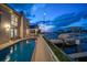 Long rectangular pool at dusk with boat dock views at 18 Winston Dr, Belleair, FL 33756