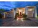 Evening view of a two-story home with a red door and landscaped yard at 18 Winston Dr, Belleair, FL 33756