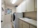 Convenient laundry room with washer, dryer, and cabinets at 18 Winston Dr, Belleair, FL 33756