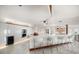 Modern white kitchen with island, stainless steel appliances, and open floor plan at 18 Winston Dr, Belleair, FL 33756