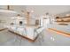 Modern kitchen with white cabinets, a large island, and a breakfast bar at 18 Winston Dr, Belleair, FL 33756