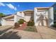 Tan two-story home with red door and attached garage at 18 Winston Dr, Belleair, FL 33756