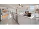 Modern kitchen with white cabinets, large island, and stainless steel appliances at 18 Winston Dr, Belleair, FL 33756