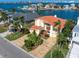 Waterfront home with terracotta roof and paved driveway at 18 Winston Dr, Belleair, FL 33756