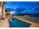 Inviting heated pool with patio and waterfront views at dusk at 18 Winston Dr, Belleair, FL 33756