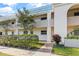 View of building exterior with manicured hedges and walkway at 1975 W Bay Dr # 214, Largo, FL 33770