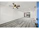 Living room with gray vinyl plank flooring, sliding doors, and ceiling fan at 1975 W Bay Dr # 214, Largo, FL 33770