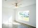 Bright bedroom with large window, ceiling fan, and wood-look tile floor at 25434 Colon Dr, Punta Gorda, FL 33983
