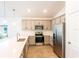 Modern kitchen with gray cabinets, quartz countertops, and stainless steel appliances at 25434 Colon Dr, Punta Gorda, FL 33983