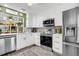 Updated kitchen with stainless steel appliances and white cabinetry at 2939 Yucca Ct, Palm Harbor, FL 34684