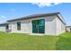 Single-story house with green walls, a black door, and a brick paved porch at 29634 Fedora Cir, Brooksville, FL 34602