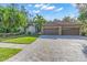Exterior showcasing a three-car garage and paver driveway at 4907 Londonderry Dr, Tampa, FL 33647