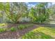 Landscaped yard with lush greenery and mature trees at 4907 Londonderry Dr, Tampa, FL 33647