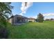 Exterior view of the backyard with a screened lanai and lush landscaping at 5721 Sunset Falls Dr, Apollo Beach, FL 33572