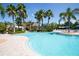 Resort style community pool with palm trees and lounge chairs on a sunny day in a luxurious community at 5721 Sunset Falls Dr, Apollo Beach, FL 33572