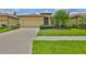 Inviting single-Gathering home featuring a well-maintained lawn, mature landscaping, and an attached garage at 5721 Sunset Falls Dr, Apollo Beach, FL 33572
