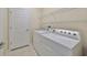 Well-lit laundry room with washer, dryer, wire shelving, and a door at 5721 Sunset Falls Dr, Apollo Beach, FL 33572