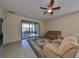Comfortable living room with tile floors, ceiling fan, and sliding glass doors to lanai at 5721 Sunset Falls Dr, Apollo Beach, FL 33572