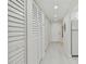 Long hallway with multiple white louvered doors and light grey flooring at 7625 Sun Island S Dr # 305, South Pasadena, FL 33707