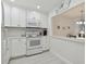 Updated white kitchen with new appliances and cabinets, and view to dining area at 7625 Sun Island S Dr # 305, South Pasadena, FL 33707