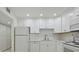 Bright white kitchen features updated appliances and cabinetry, and stylish white subway tile backsplash at 7625 Sun Island S Dr # 305, South Pasadena, FL 33707