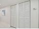 White walls and louvered doors in a condo hallway at 7625 Sun Island S Dr # 305, South Pasadena, FL 33707