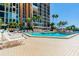 Community pool with surrounding lounge chairs at 7625 Sun Island S Dr # 305, South Pasadena, FL 33707