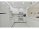 Bright white kitchen with updated appliances and cabinets, and view to dining area at 7625 Sun Island S Dr # 305, South Pasadena, FL 33707