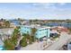 Teal building near the water with surrounding houses and palm trees at 8200 Bayshore Dr # 12, Treasure Island, FL 33706