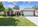 Brick home with landscaped yard, two-car garage at 8910 Beeler Dr, Tampa, FL 33626