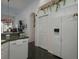 Kitchen with white appliances and a view into hallway at 19109 Cherry Rose Cir, Lutz, FL 33558